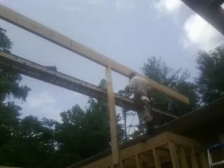 Carpenter setting a ridge beam over a new addition frame — Ice Dam Removal by Roofing Brothers in Wyndmere