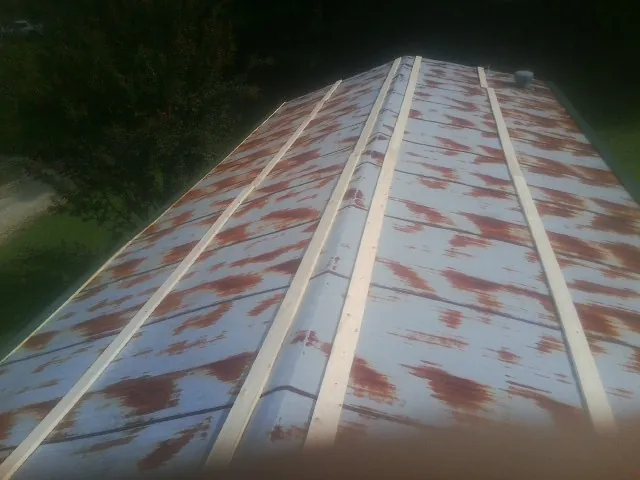 Rusted metal roof panels with new wood purlins before replacement — Storm Damage Roof Repair in Wyndmere by Roofing Brothers